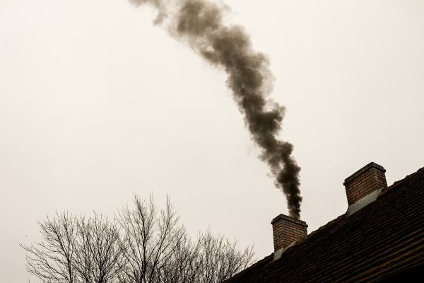 chimney with coal smoke billowing out of it